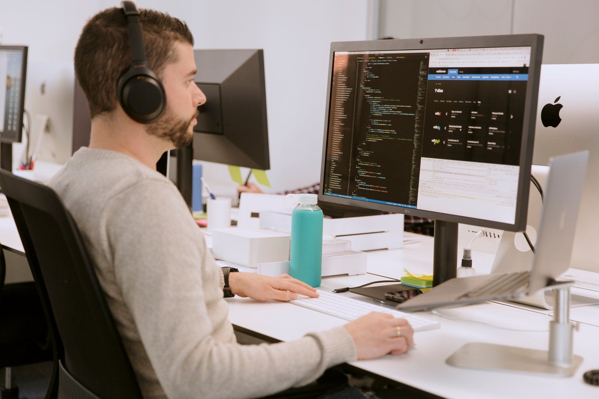 Desarrollador con cascos programando frente a un monitor